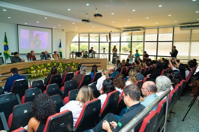 Plenário do TRE lotado de pessoas; e na bancada estão o presidente do TRE, um juiz, uma juíza e ...