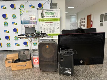 Cinco pessoas sorridentes posam em um ambiente interno, ao lado de um carrinho do Boticário com ...