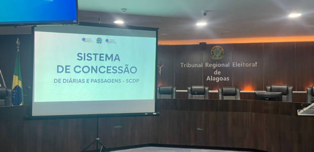 Capacitação Sistema de Concessão de Diárias e Passagens - SCDP - 16.01.2025 Na foto, imagens do plenário do TRE de Alagoas. Do lado esquerdo da imagem, um telão e a Bandeir...