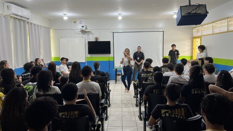 Em uma sala de aula, uma pessoa conduz uma atividade educativa diante de um grupo de estudantes ...