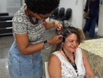 A imagem mostra uma mesa redonda coberta com toalha branca, onde estão expostos diversos itens a...