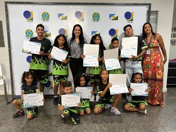 A imagem mostra uma mesa redonda coberta com toalha branca, onde estão expostos diversos itens a...