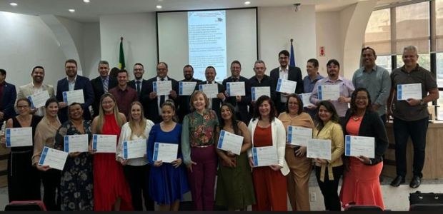 Formatura da 1ª Turma do Curso de Pós-Graduação Lato Sensu de Especialização em Financiamento de Campanha e Prestação de Contas Anuais e Eleitorais Na foto, várias pessoas, entre homens e mulheres estão em um auditório de paredes brancas. Elas ...