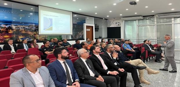 Foto: TRE-RR/Ascom/1ª Reunião com as forças de segurança para tratar das Eleições 2024/02.08.2024 Em um ambiente fechado com paredes de vidro e portas laterais também de vidro, pessoas sentadas ...