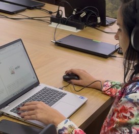 Foto de uma mesa em ambiente interno com várias mochilas pretas alinhadas. Sobre cada mochila há...