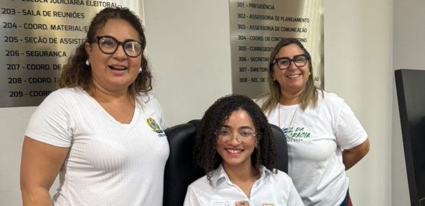Janeiro Branco imagem com 3 mulheres, estando duas em pé e uma sentada em poltrona preta. Todas usam óculos de ...