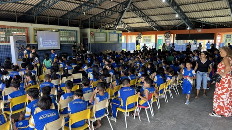 A imagem mostra uma pessoa posicionada diante de uma urna eletrônica. A mão dessa pessoa está ap...