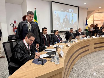 Imagem mostra uma mesa de sessão do Judiciário com vários homens adultos usando vestes formais p...