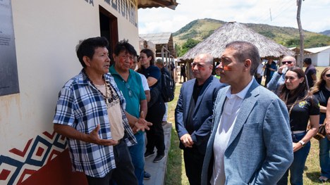 Em uma maloca com cobertura de palha, dezenas de jovens indígenas participam de uma atividade ed...