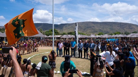 Em uma maloca com cobertura de palha, dezenas de jovens indígenas participam de uma atividade ed...
