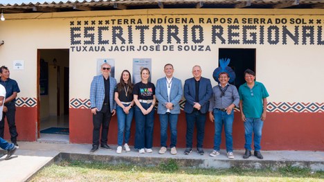 Em uma maloca com cobertura de palha, dezenas de jovens indígenas participam de uma atividade ed...