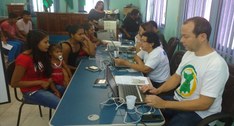 3 Servidores do TRE-RR estão sentados, digitando no notebook e à frente deles 3 eleitoras
