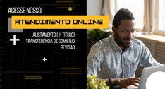 Do lado direito da imagem, homem sentado digitando na frente do computador; do lado esquerdo, co...