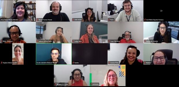 Captura de tela de uma reunião virtual em formato de grade, com cerca de 15 participantes. A mai...