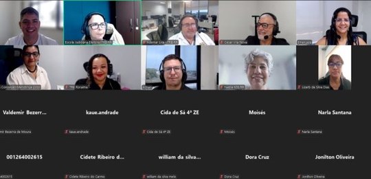 A imagem mostra a tela de uma videoconferência realizada na plataforma Zoom. Na parte superior, ...