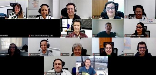 A imagem mostra uma videoconferência com 15 pessoas distribuídas em pequenos quadros na tela. To...