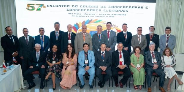 TRE-RR-  Programação do 57º Encontro Nacional de Corregedoras e Corregedores Eleitorais A foto mostra um grupo de 20 pessoas, entre homens e mulheres, posando formalmente diante de um ...