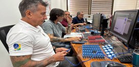 Servidores utilizam computadores para configurar equipamentos com cabos e dispositivos organizad...