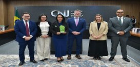Foto oficial em ambiente institucional do Conselho Nacional de Justiça (CNJ). Cinco pessoas estã...