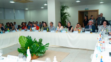 A imagem mostra um grande grupo de pessoas reunidas para uma foto oficial em um evento. São cerc...