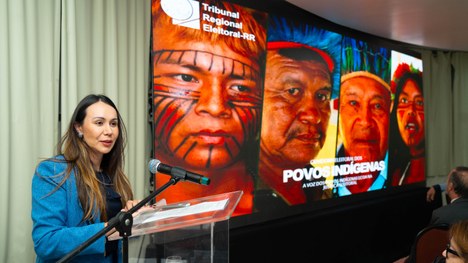 A imagem mostra um grande grupo de pessoas reunidas para uma foto oficial em um evento. São cerc...