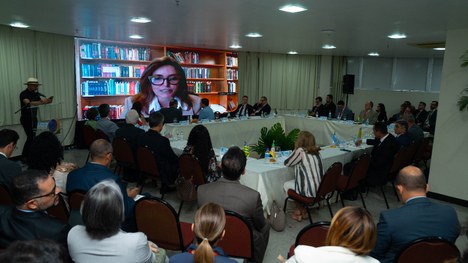 A imagem mostra um grande grupo de pessoas reunidas para uma foto oficial em um evento. São cerc...
