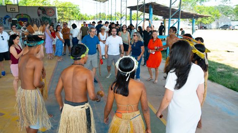 A imagem mostra um grande grupo de pessoas reunidas para uma foto oficial em um evento. São cerc...