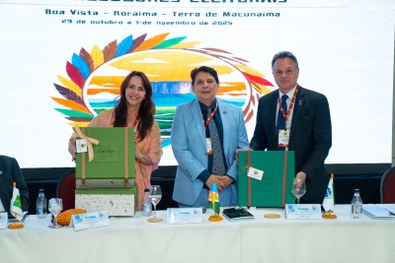 A imagem mostra um grande grupo de pessoas reunidas para uma foto oficial em um evento. São cerc...