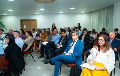 A imagem mostra um grande grupo de pessoas reunidas para uma foto oficial em um evento. São cerc...