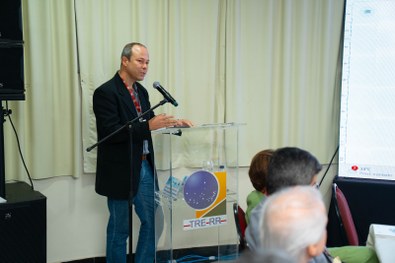 A imagem mostra um grande grupo de pessoas reunidas para uma foto oficial em um evento. São cerc...