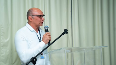 A imagem mostra um grande grupo de pessoas reunidas para uma foto oficial em um evento. São cerc...