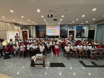 Pessoas visitam o “Espaço Memória TRE-RR”, observando vitrines com documentos e objetos antigos....