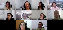 Imagem mostra uma reunião virtual com dez participantes sorridentes, todos usando fones de ouvid...