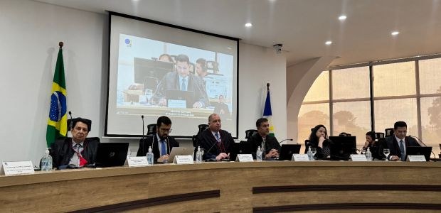 Vereador de São Luiz do Anauá tem mandato cassado Mesa com sete pessoas em uma sessão oficial em auditório. Ao fundo, há uma tela projetando a ima...
